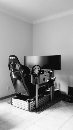 a black and white photo of a car seat in front of a television set on a stand