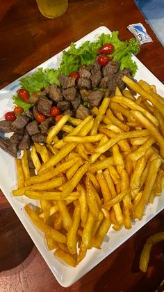 a white plate topped with french fries and steak