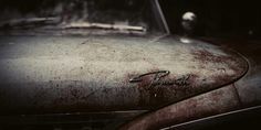 an old car with rust on the hood