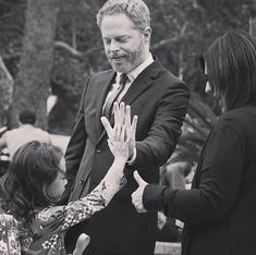 two women and a man are giving each other high fives in black and white