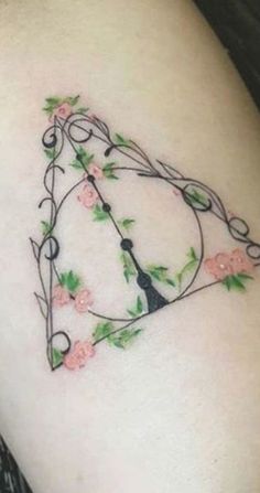 a tattoo design on the side of a woman's arm with flowers and a clock