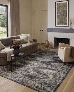 a living room filled with furniture and a large rug on top of a hard wood floor