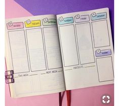 an open planner book sitting on top of a pink table