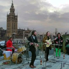 a group of people standing on top of a roof next to each other playing instruments