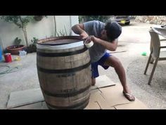 a man that is leaning over a barrel