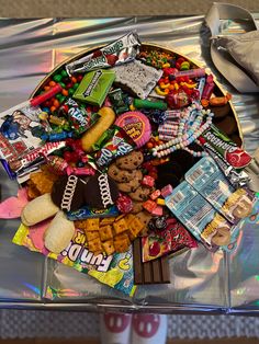 a tray filled with candy and candies on top of a metal table next to a pair of red shoes