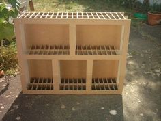 a wooden shelf sitting on top of a cement ground next to a tree and bushes