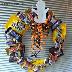 a wreath made out of candy bars and halloween decorations