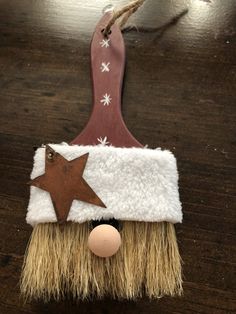 a broom with a star on it hanging from a string