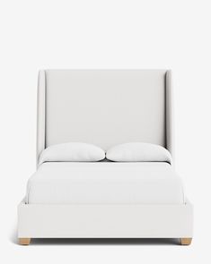 a white bed with two pillows on it