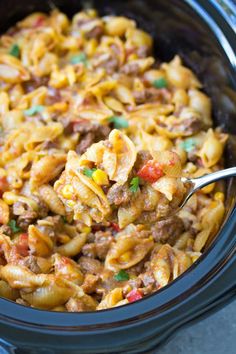 a crock pot filled with pasta and ground beef is ready to be served in the slow cooker