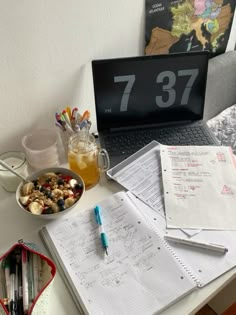 an open laptop computer sitting on top of a desk next to a bowl of food