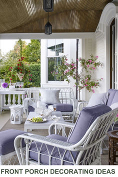 the porch is decorated with white wicker furniture and purple cushions, along with pink flowers