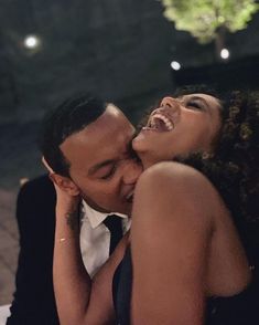 a man and woman kissing each other while sitting at a table