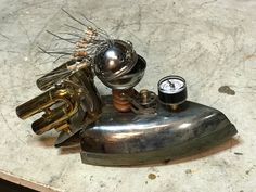 a metal object sitting on top of a table next to a gauge and other items