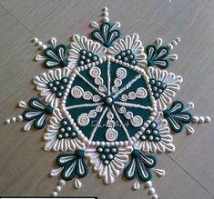 a white and blue snowflake sitting on top of a wooden floor