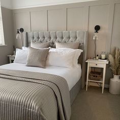 a bed with white sheets and pillows in a bedroom