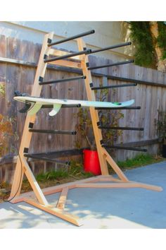 a wooden surfboard rack in front of a fence