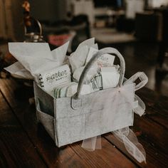 a white basket filled with lots of items on top of a wooden table