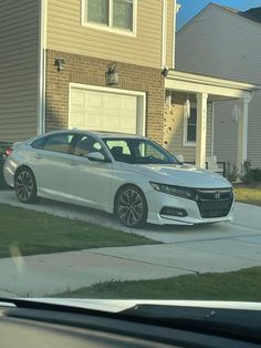 a white car parked in front of a house