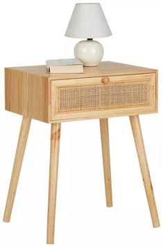 a wooden table with a white lamp on top and a book in front of it