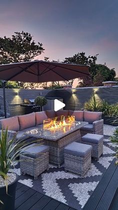 a fire pit sitting on top of a wooden deck next to a patio with lots of furniture