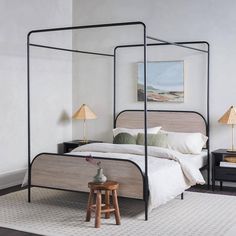 a bedroom with a four poster bed and two nightstands on either side of the bed