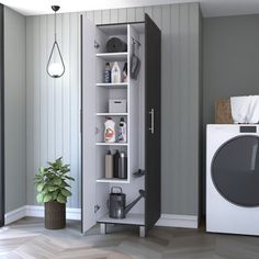 a washer sitting next to a dryer in a room with grey walls and wooden floors