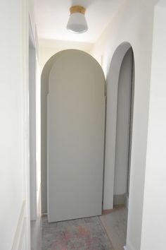 an arched doorway leading to another room with a rug on the floor in front of it