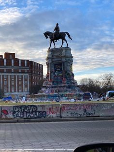 there is a statue with a horse and rider on it in front of some buildings