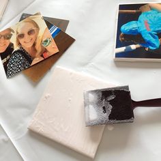 some pictures and a paint roller on a white table with other things in the background