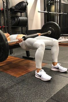 a woman doing squats with a barbell