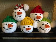 crocheted snowmen sitting on top of a shelf