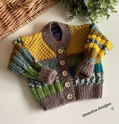 a knitted sweater sitting on top of a table next to a basket and plant