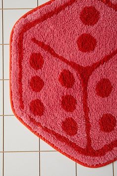 a close up of a rug on a tile floor with red and black dices