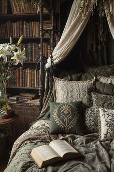 a bed covered in lots of pillows and blankets next to a book shelf filled with books