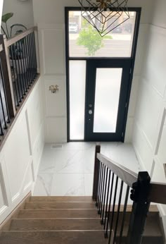 an overhead view of stairs leading to a door and window in a house with white walls