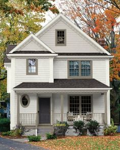 a white two story house with black shutters on the front and side porches