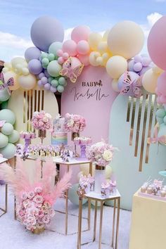 a table topped with lots of pink flowers and balloons