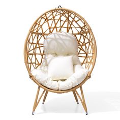 an egg chair with white pillows on it