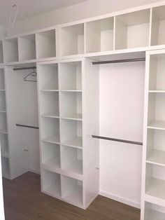 an empty room with white bookcases and wooden floors