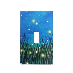 a light switch cover with grass and stars in the night sky on blue watercolor paper