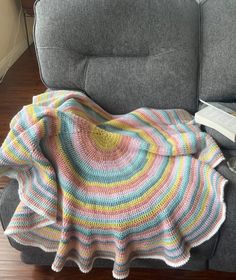 a couch with a blanket on top of it and a book laying next to it