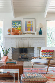 a living room filled with furniture and a fire place in front of a white brick fireplace