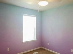 empty room with purple walls and tan carpet