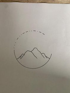 a piece of paper with a drawing of mountains in the middle on top of it