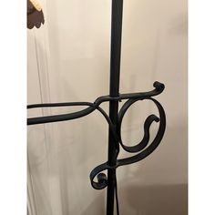 a black wrought iron lamp on a white wall