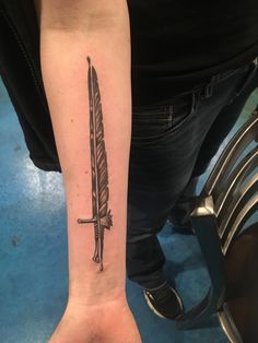 a person with a tattoo on their arm holding a knife