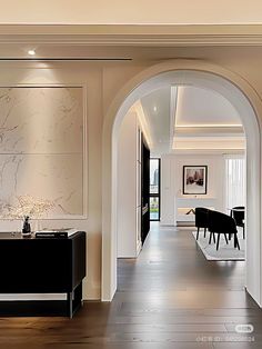 an archway leading to a living room and dining room with marbled wall art on the walls