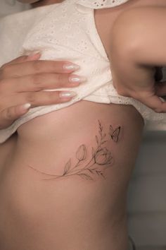 a woman's stomach with a flower tattoo on her belly and the bottom part of her abdomen